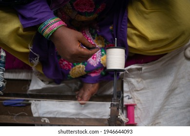 Khargone, Madhya Pradesh, India- July 14 2016: A Weaver Prepares Threads To Make Fabric With A Handloom, Female Artisan Spins Yarn On An Old Fashioned Spinning Wheel.