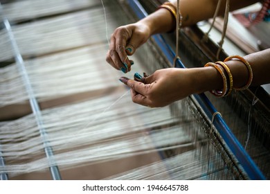Khargone, Madhya Pradesh, India- July 14 2016: A empowered woman weaver prepares threads to make maheshwari saree with a handloom at workshop.