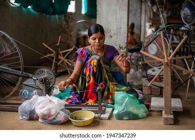 Khargone, Madhya Pradesh, India- July 14 2016: A Weaver Prepares Threads To Make Fabric With A Handloom, Female Artisan Spins Yarn On An Old Fashioned Spinning Wheel.