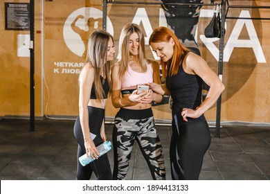 Kharkiv, Ukraine 05.01.21 Three Girls Stand Together In Gym, And One Shows Them A Video On The Phone