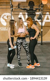 Kharkiv, Ukraine 05.01.21 Three Girls Stand Together In Gym, And One Shows Them A Video On The Phone