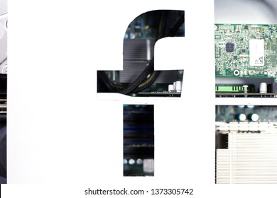 Kharkiv, Ukraine - 16 April 2019: Illustrative Editorial Of Facebook Social Media Logo Cut Out Of White Paper, Circuit Server Board Behind Of It. Facebook News, Fake News Concept. 