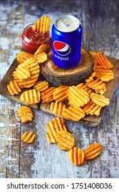 Kharkiv / Ukraine - June 07, 2020: Pepsi Can and chips with sauce. Selective focus. Macro. The composition of Pepsi and potato chips. Unhealthy food. American snack.
