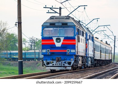 Kharkiv, Ukraine - Spring 2021: Two Beautiful Powerful Diesel Locomotives Pulling A Long Passenger Intercity Train. A Winding Road. Ukrainian Railway