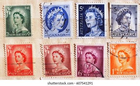 KHARKIV,UKRAINE - MARCH 24,2017: Collection of old used Commonwealth countries postal stamps with portraits of Queen Elizabeth II in an album, as philatelic background.