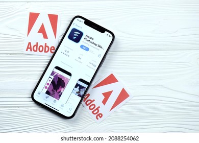 KHARKOV, UKRAINE - MARCH 5, 2021: Adobe Photoshop Icon And Application From App Store On IPhone 12 Pro Display Screen On White Wooden Table