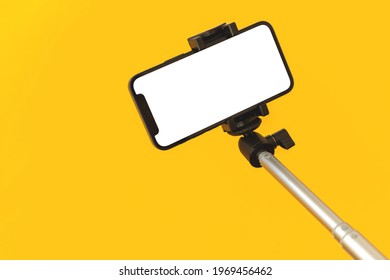 Kharkov, Ukraine - May 5, 2021: Apple IPhone On A Selfie Stick Mockup Screen On Yellow Background