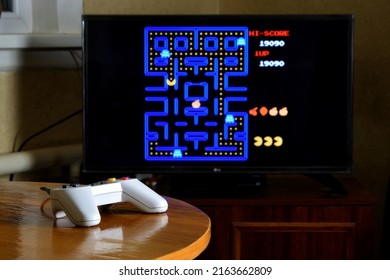 KHARKOV, UKRAINE - NOVEMBER 12, 2020: Dendy Video Game Controller On Table With Pac Man Game On Big Display