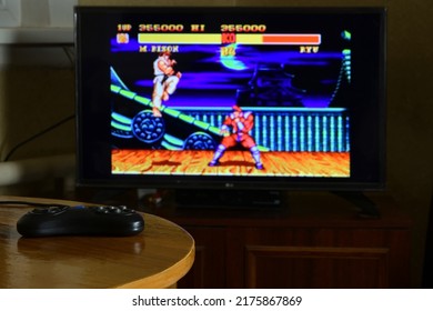 KHARKOV, UKRAINE - NOVEMBER 12, 2020: Sega Mega Drive Video Game Controller On Table With Street Fighter 2 Game On Big Display