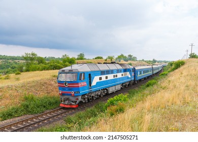 Kherson, Ukraine - Autumn 2021: Diesel Locomotive TEP70 Pulls A Long Intercity Passenger Train Along A Winding Road Through The Ukrainian Steppe. Ukrainian Railway