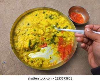Khichdi is a popular Indian dish prepared by boiling lentils and rice together.This is especially useful for patients. Khichdi or normal khichdi Rice Urad black pulses with peel Lentils Salt Bhedadi  - Shutterstock ID 2253893901