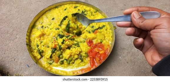 Khichdi is a popular Indian dish prepared by boiling lentils and rice together.This is especially useful for patients. Khichdi or normal khichdi Rice Urad black pulses with peel Lentils Salt Bhedadi  - Shutterstock ID 2253893915