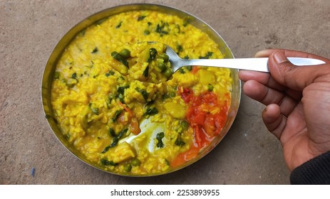 Khichdi is a popular Indian dish prepared by boiling lentils and rice together.This is especially useful for patients. Khichdi or normal khichdi Rice Urad black pulses with peel Lentils Salt Bhedadi  - Shutterstock ID 2253893955