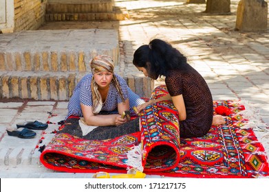 KHIVA, UZBEKISTAN - JUNE 4, 2011: Two unidentified Uzbek women are working on a carpet in Uzbekistan, Jun 4, 2011. 93% of Uzbek people consider that life in the country goes well.