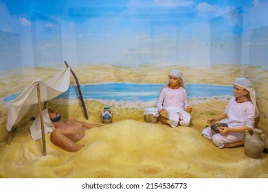 Khiva, Uzbekistan - May 09, 2022. Exposition depicting old Central Asian methods of traditional medicine. Patient is buried in sand, his head is covered from sun. Physician assistants observe patient