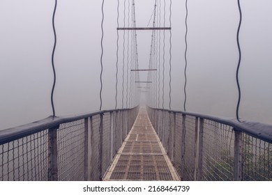 Khndzoresk suspension swinging bridge in fog. Suspension bridge over the gorge near Goris village. Early misty morning. Spooky atmosphere