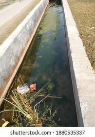 Khulna, Bangladesh: December 22, 2020: An open drain with two side brick wall. roadside drain, green algae grown up in water.