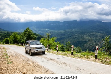 Khvamli, Georgia, 05.06.21.  Mitsubishi Pajero IO 4x4 Off-road Car Driving On A Gravel Road Uphill Towards Khvamli Mountain Peak In Lush Green Tskhenistsqali Valley In Racha Region In Georgia.