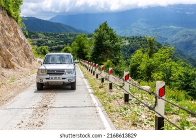 Khvamli, Georgia, 05.06.21.  Mitsubishi Pajero IO 4x4 Off-road Car Driving On A Gravel Road Uphill Towards Khvamli Mountain Peak In Lush Green Tskhenistsqali Valley In Racha Region In Georgia.