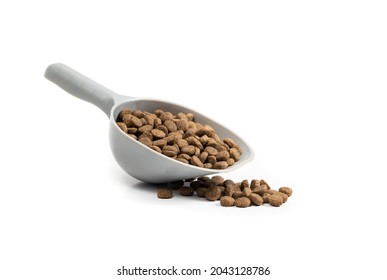 Kibbles In Measuring Cup And Some Random Pieces. 1 Cup Dry Pet Food Portioned Out A Medium To Large Dog. Brown Small Oval Pebbles. Isolated On White. Selective Focus.