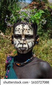 Kibish, Ethiopia - 01/01/2014. Boy from Surmi tribe, with painted face and natural decorations of leave. Surmi are also called Suri or Surma