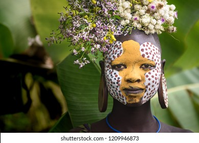KIBISH, ETHIOPIA - AUGUST 22, 2018: unidentified woman from Surmi tribe, with flower decorations. Surmi are also called Suri or Surma and live in villages in the south wester part of Ethiopia