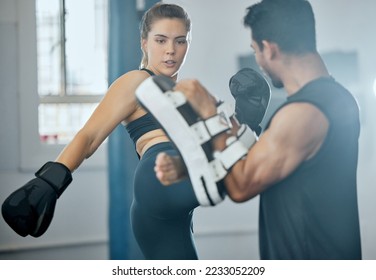 Kick boxing, training and fitness woman with trainer exercising, doing self defense workout or fitness activity in a wellness gym. Determined, strong and athletic people in a sports or exercise class