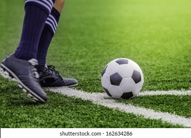 Kick Off Soccer Ball With His Feet On The Football Field