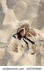 Kick Off Your Shoes And Enjoy The Summer On The Beach Concept With Brown Leather Thong Sandals Laying In The Sand With Copy Space