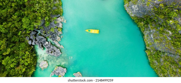 Kick Off Your Summer With An Island Cruise. High Angle Shot Of A Boat Sailing Through A Canal Running Along The Raja Ampat Islands In Indonesia.