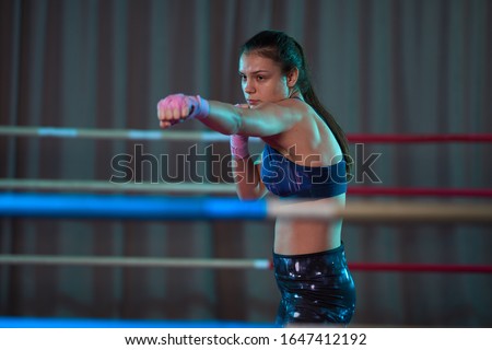 Kickboxer girl shadow boxing in the ring before sparring