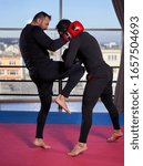 Kickboxer hitting pads with his coach in the gym