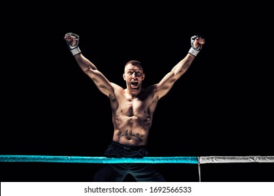 Kickboxer posing in the ring. The athlete climbed the ropes and took a winning pose. The concept of mma, wrestling, muay thai. Mixed media - Powered by Shutterstock