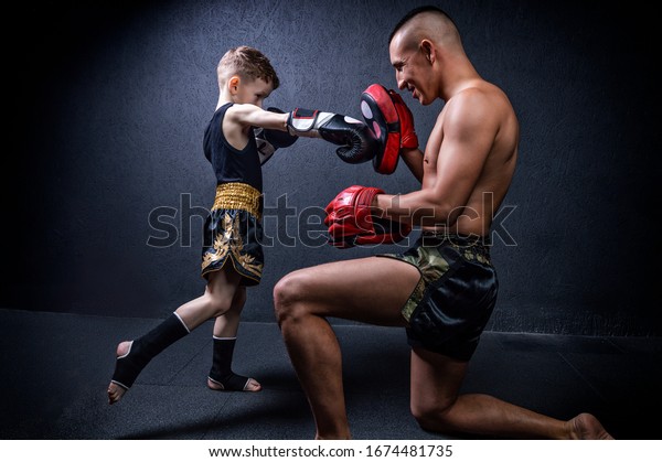 Kickboxing coach is training the boy.\
The concept of family, sports, mma, muay thai. Mixed\
media