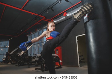 Kickboxing Woman Punching Kicking Bag At The Gym