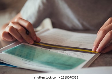 Kid Affected By Dyslexia Doing Homework, Writing, Reading Notebook Task Using Colorful Overlay Strip. Education, Learning Disability, Reading Difficulties Concept