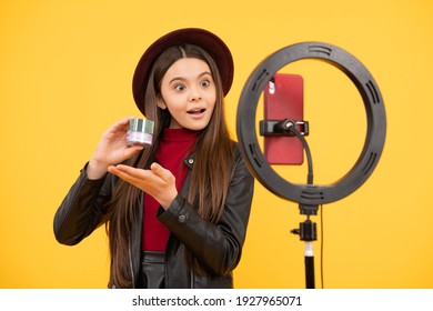 kid beauty blogger. cheerful child do makeup. vlogger with cosmetics. making video blog on phone. blogging ring lamp. weblog and vlog. makeup tutorial. influencer. amazed teen girl use selfie led.