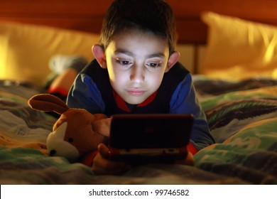 Kid In Bed Wih Videogame Console