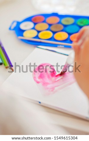 A kid being creative, creating art with water colors and being artistic