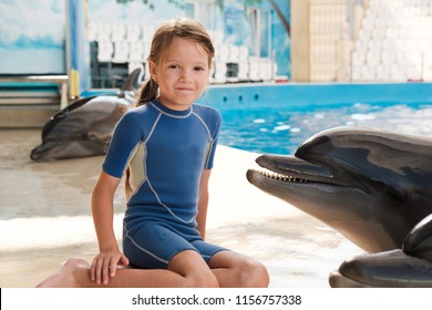 Kid With Bottlenose Dolphin. Little Girl And Dolphin On Stage. Dolphin Assisted Therapy