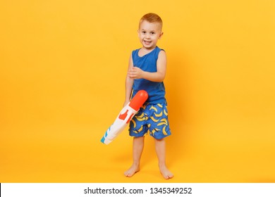 Kid Boy 3-4 Years Old In Blue Beach Summer Clothes Hold Toy Water Gun Isolated On Bright Yellow Orange Wall Background Children Studio Portrait. People Childhood Lifestyle Concept. Mock Up Copy Space