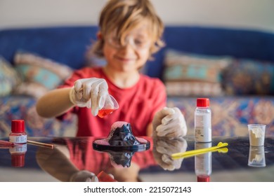 Kid boy doing chemical experiment at home. Child with protective glasses study using pipette dropping liquid to test tube, caucasian, biochemistry. chemistry class. home school concept - Powered by Shutterstock