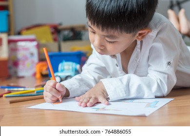 kid boy drawing with color pencils,Hand of asian child draw and paint with crayon in vintage color tone - Powered by Shutterstock