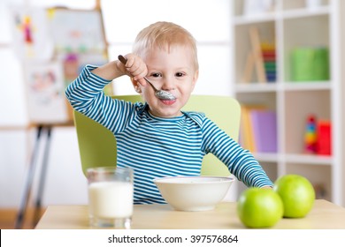 kid boy eating healthy food at home or daycare