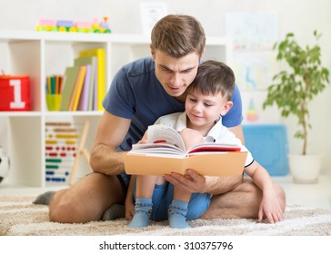 Kid Boy And Father Reading A Book Indoors