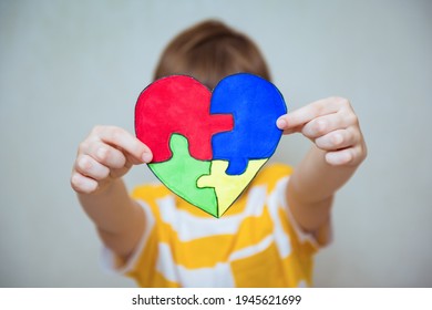 Kid boy hands holding drawing of a heart, child mental health concept, world autism awareness day, teen autism spectrum disorder awareness concept