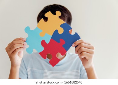 Kid Boy Hands Holding Puzzle Jigsaw,  Child Mental Health Concept, World Autism Awareness Day, Teen Autism Spectrum Disorder Awareness Concept