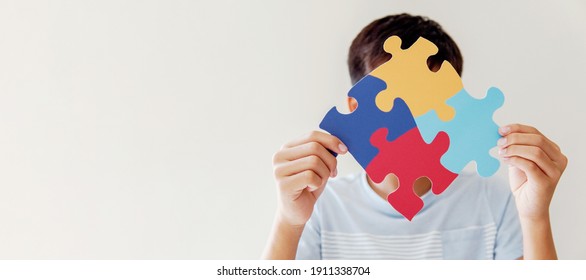 Kid Boy Hands Holding Puzzle Jigsaw,  Mental Health Concept, World Autism Awareness Day