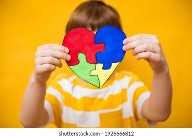 Kid Boy Hands Holding Puzzle Heart, Child Mental Health Concept, World Autism Awareness Day, Teen Autism Spectrum Disorder Awareness Concept