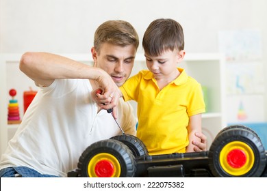 Kid Boy And His Dad Repair Toy Trunk